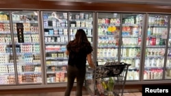 FILE - A woman shops in a supermarket as rising inflation affects consumer prices in Los Angeles, California, June 13, 2022.