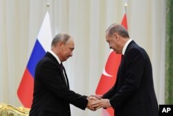 Rusya Cumhurbaşkanı Vladimir Putin ve Cumhurbaşkanı Recep Tayyip Erdoğan İran'da yapılan üçlü Suriye zirvesinde tokalaşırken, 7 Eylül 2018.